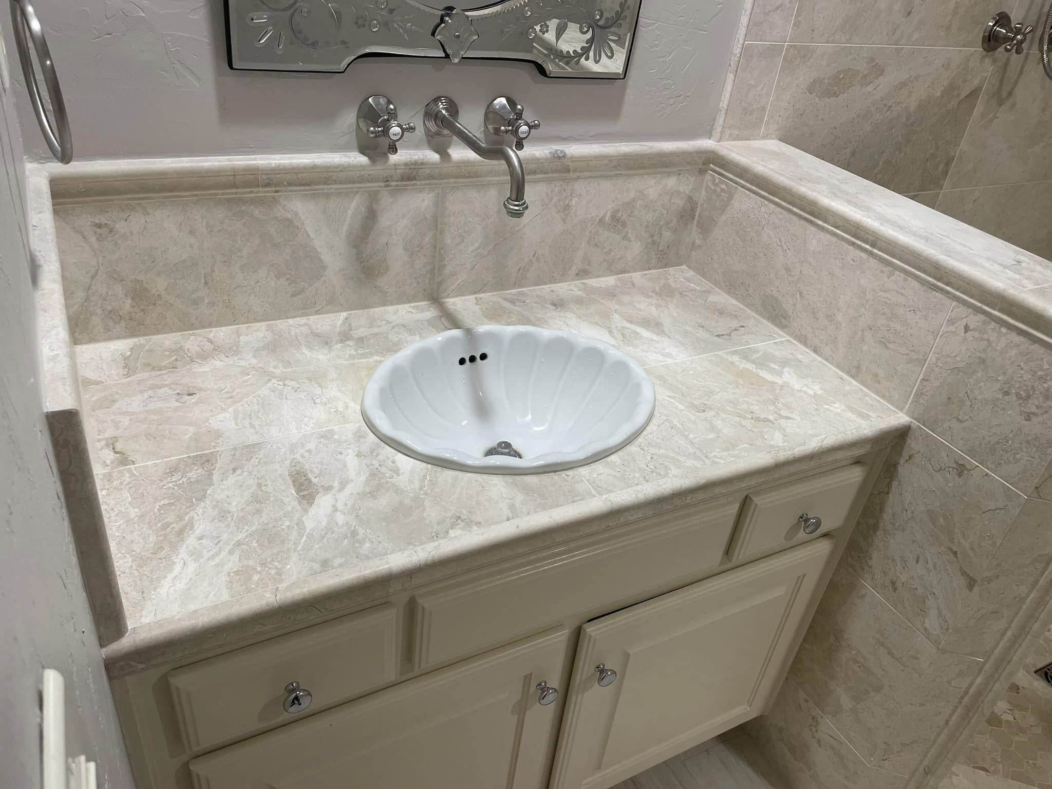 Travertine-tile vanity countertop with a vintage shell-shaped sink basin, McKinney bathroom remodel
