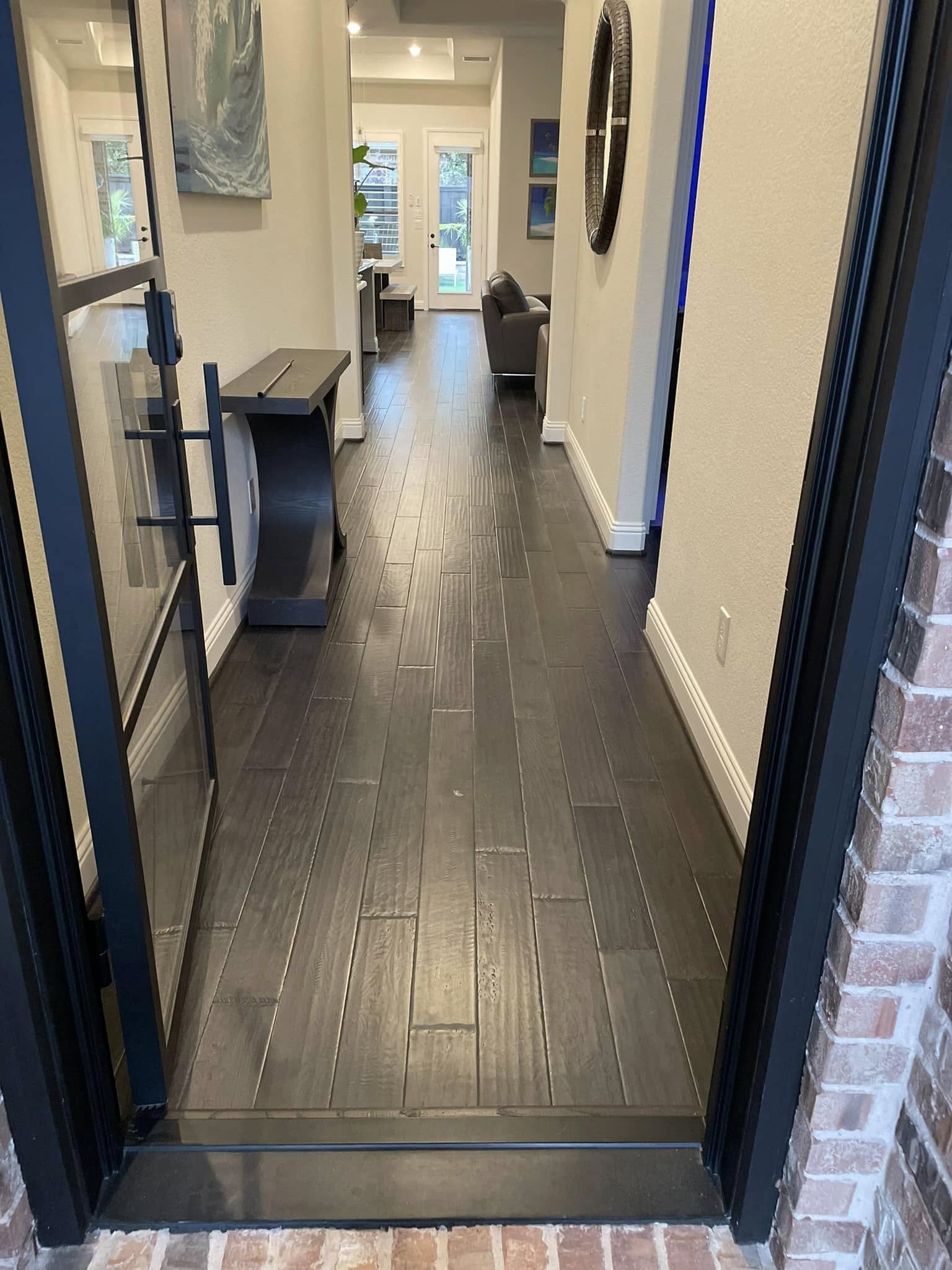 Dark wood-look porcelain tile foyer floor installation by Andrades GC