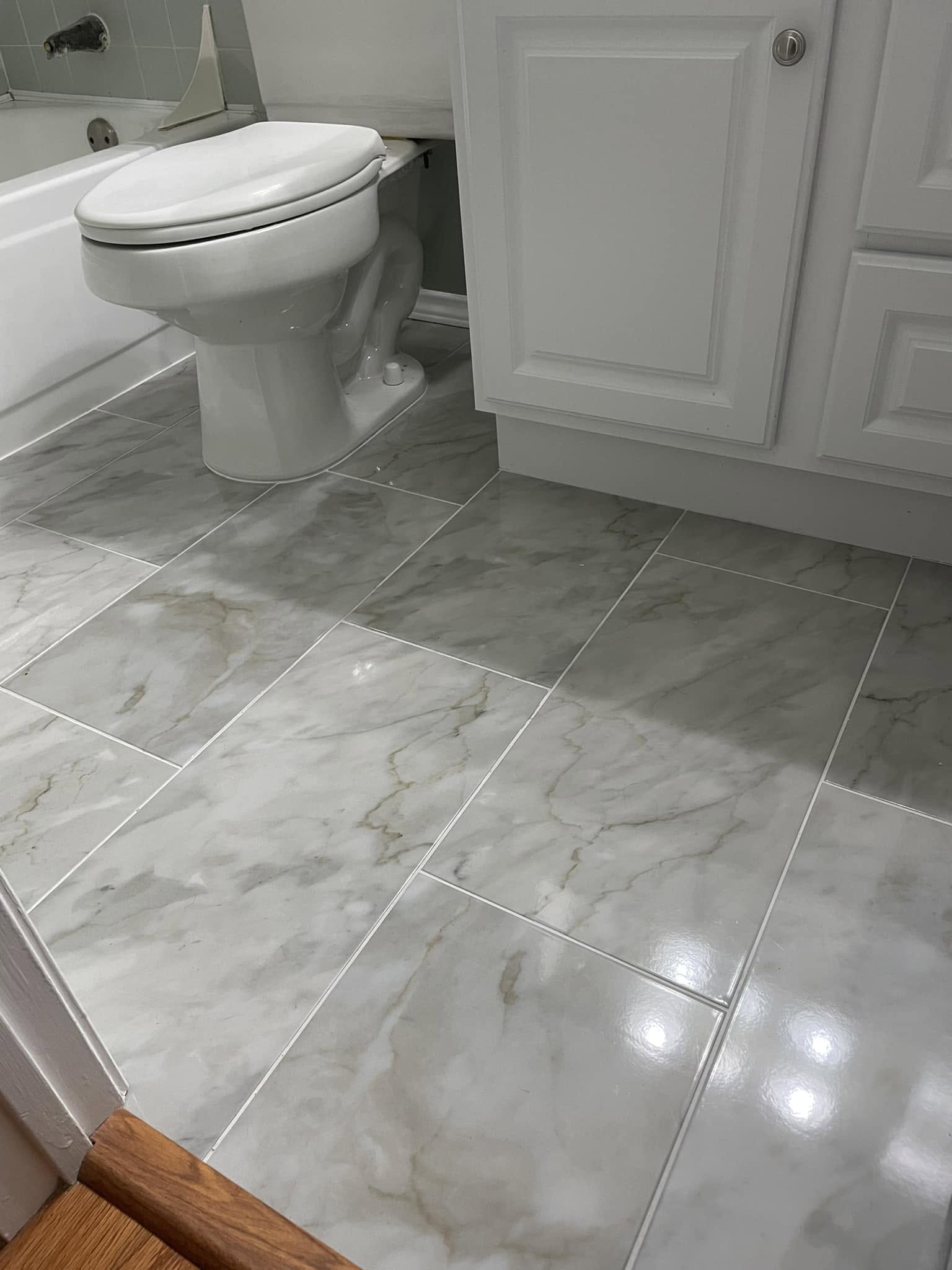 Marble-look porcelain tile floor installation in a McKinney guest bathroom