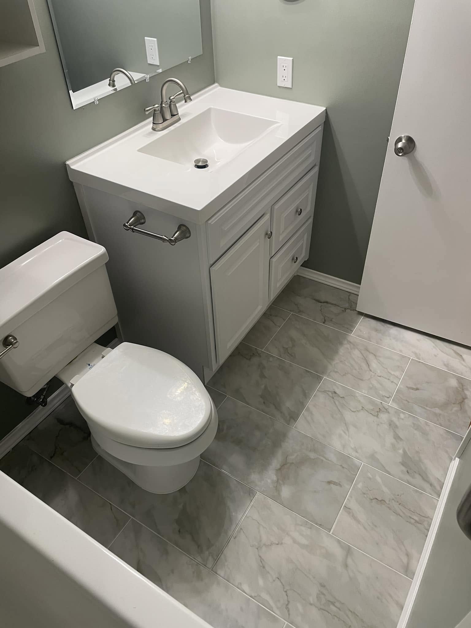 Guest bathroom remodel with white vanity and marble-look porcelain tile flooring, McKinney TX