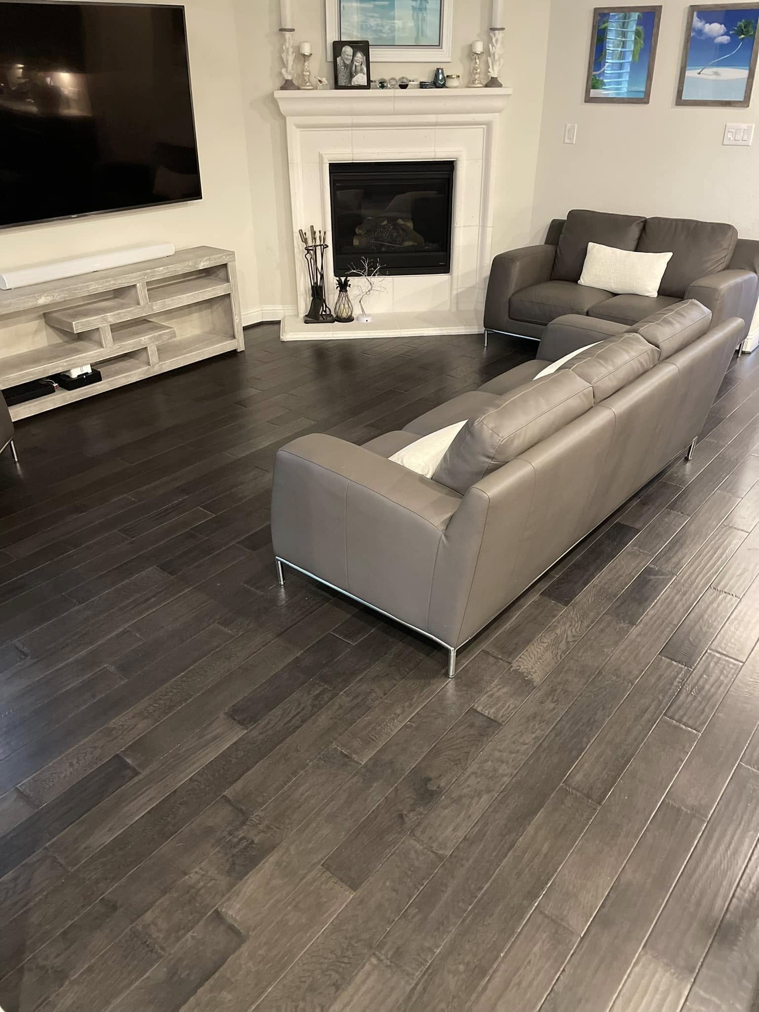 Dark hardwood living room floor with brick fireplace, residential build by Andrades GC