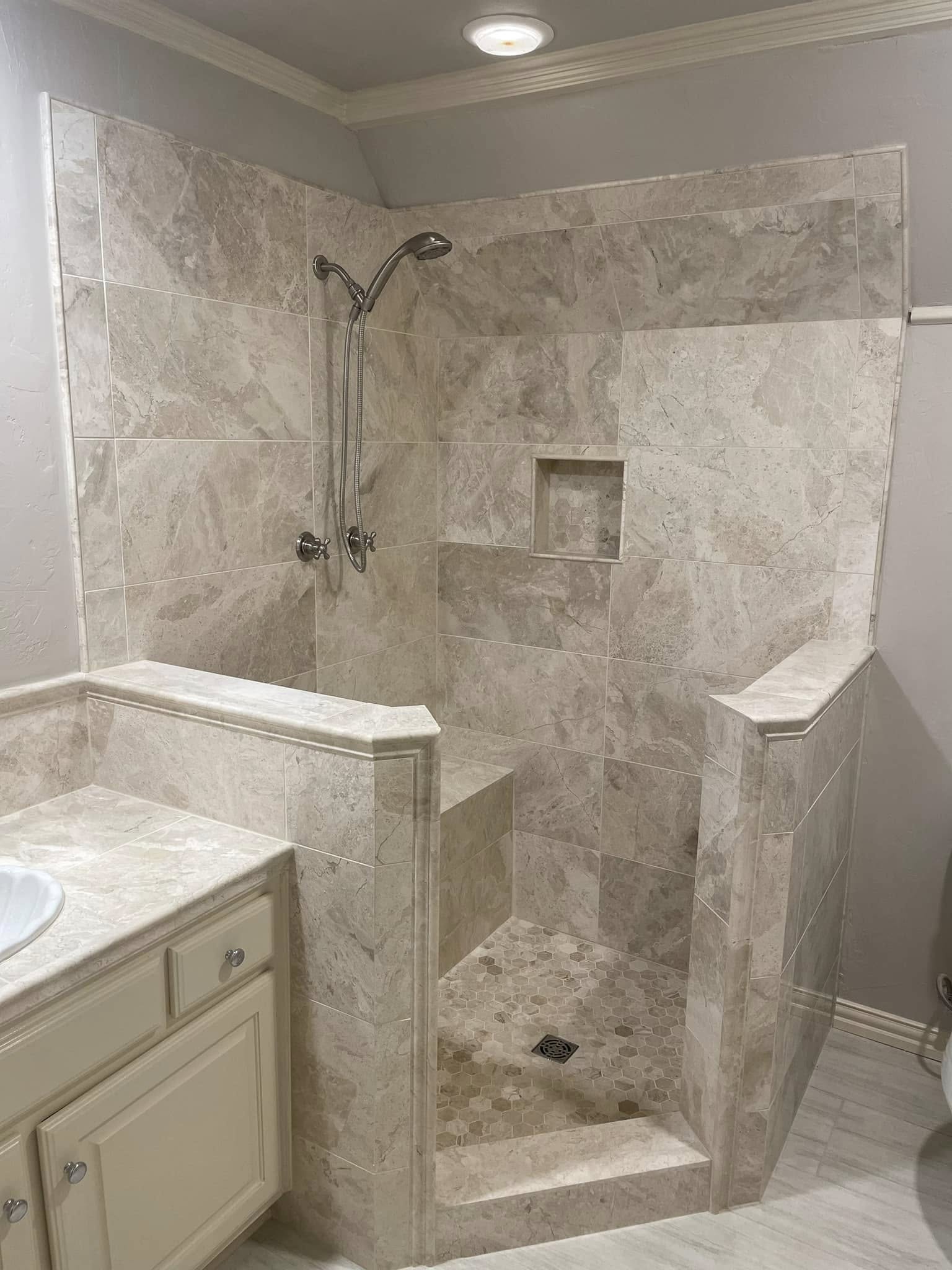 Travertine-tile corner walk-in shower remodel in a McKinney, TX master bathroom by Andrades GC