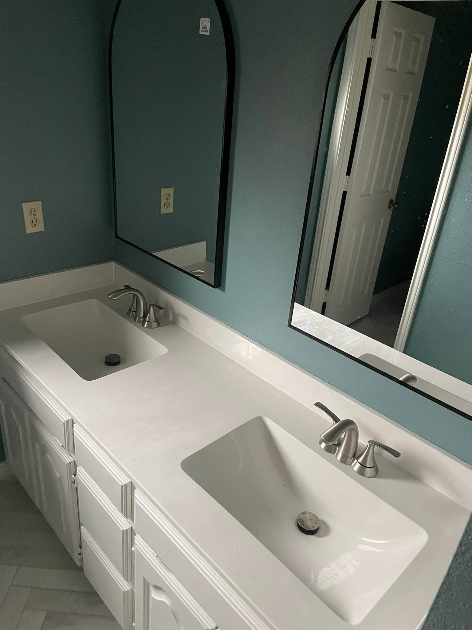 White double vanity with quartz countertop and arched mirrors against a teal wall, McKinney master bathroom